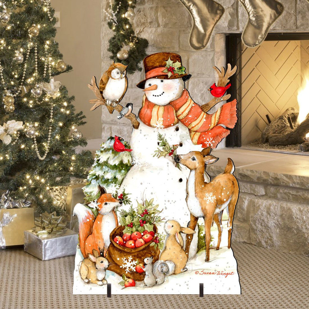 Outdoor yard sign featuring smiling snowman in orange scarf, deer, bird, and rabbits