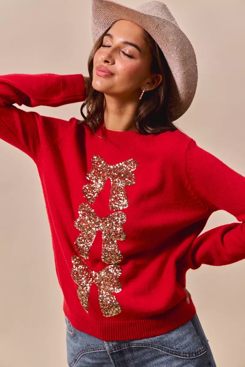 Red crewneck sweater with gold sequin bow ribbon embellishment and ribbed hem