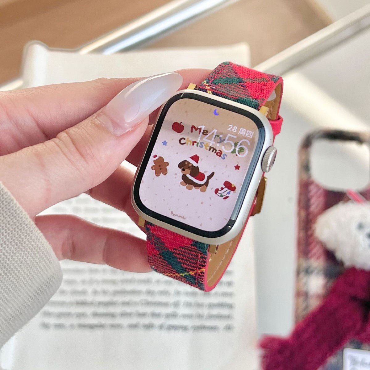 Christmas watch strap in red and green woven pattern with metal clasp, shown on a wrist