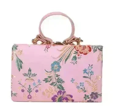 Light pink floral clutch bag with colorful botanical print and loop top handles