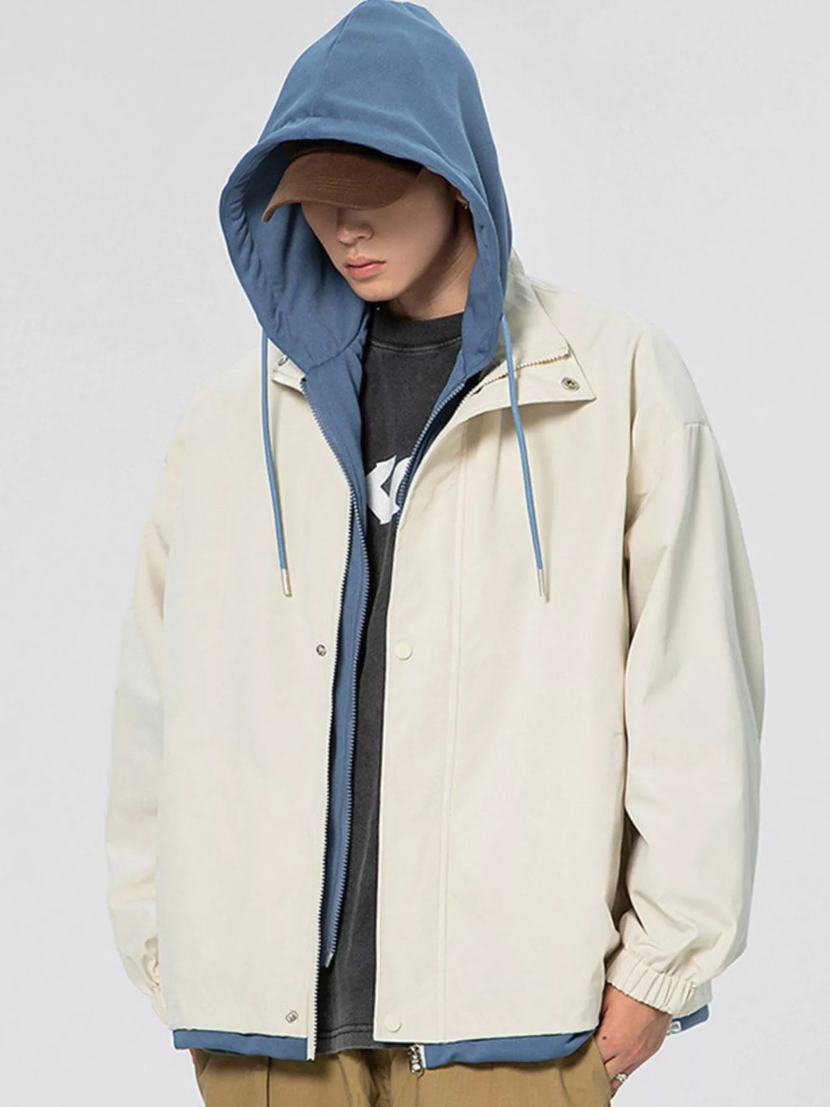 Light khaki windbreaker jacket with blue hood lining, front zipper, and drawstring cords