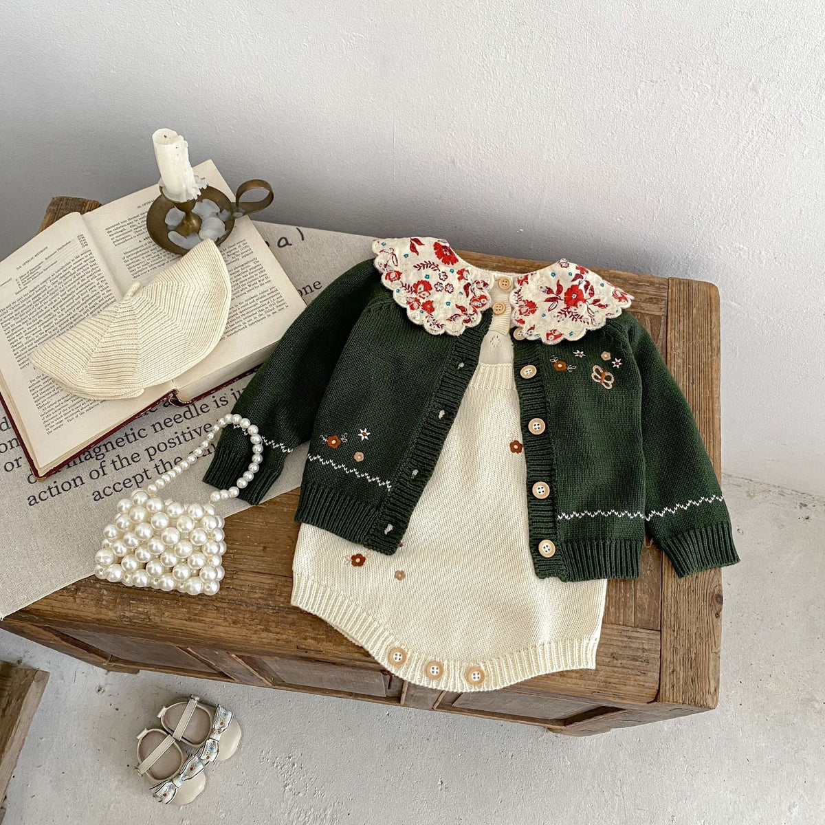Infant knit cardigan set: dark green button-front top with floral collar and cream romper