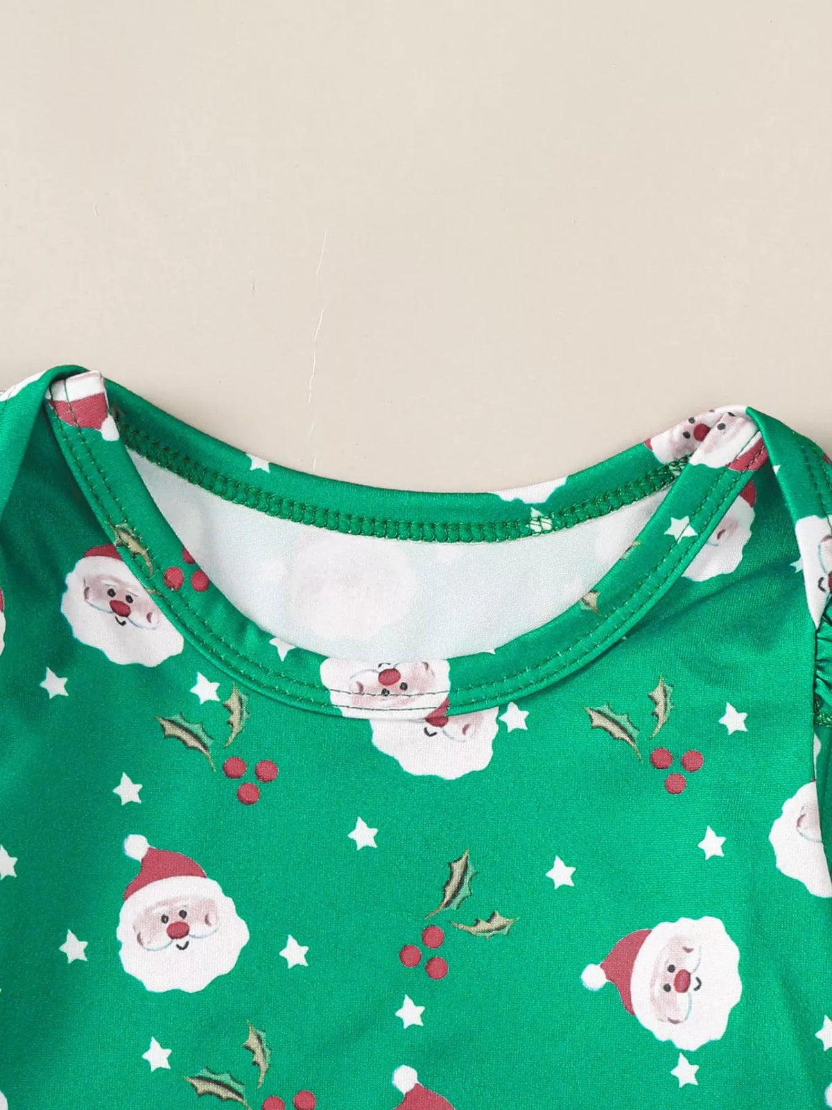 Green holiday-print bodysuit with round neckline and Santa and star graphics