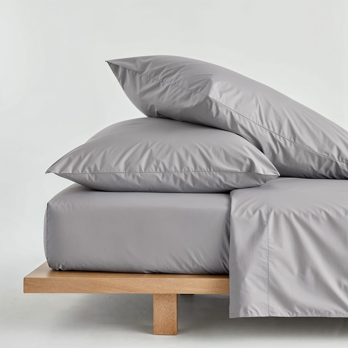 Gray sateen bedding bundle with duvet set and two pillows, neatly folded