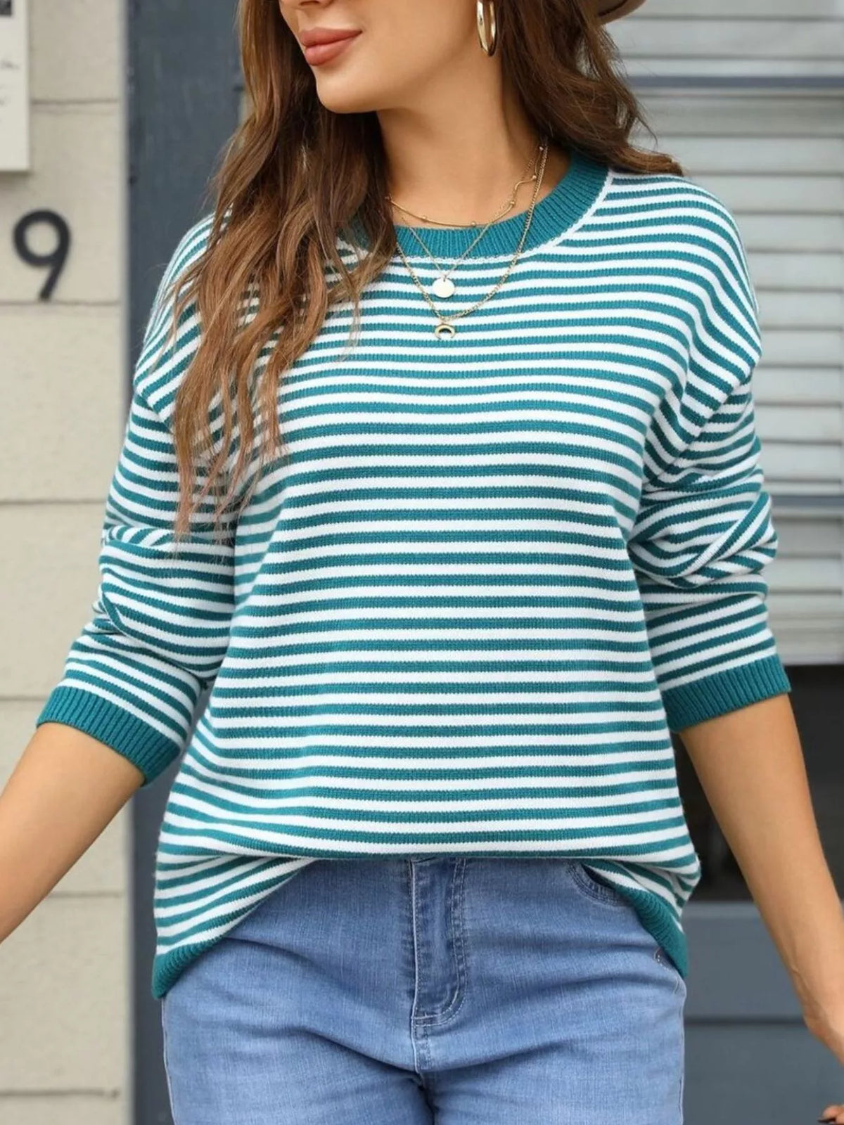 Teal-and-white striped round-neck sweater with long sleeves and ribbed trim