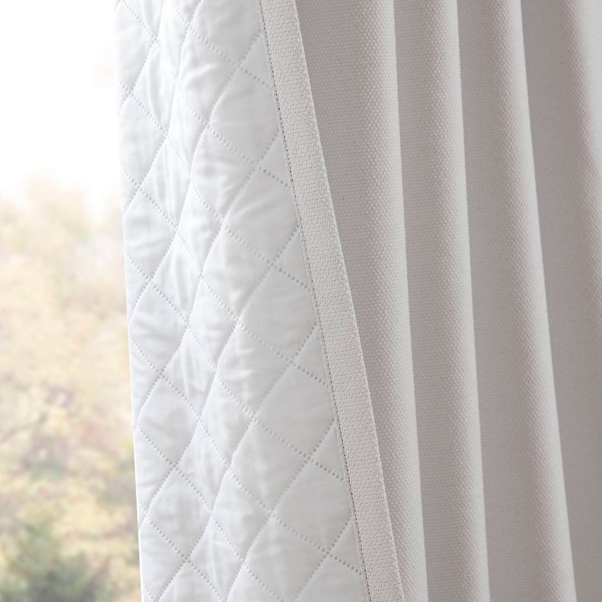 White curtain panel close-up with diagonal quilted pattern and soft texture