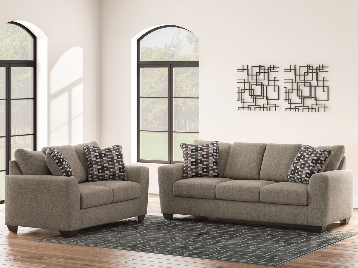Beige fabric loveseat and accent chair with black-and-white geometric pillows
