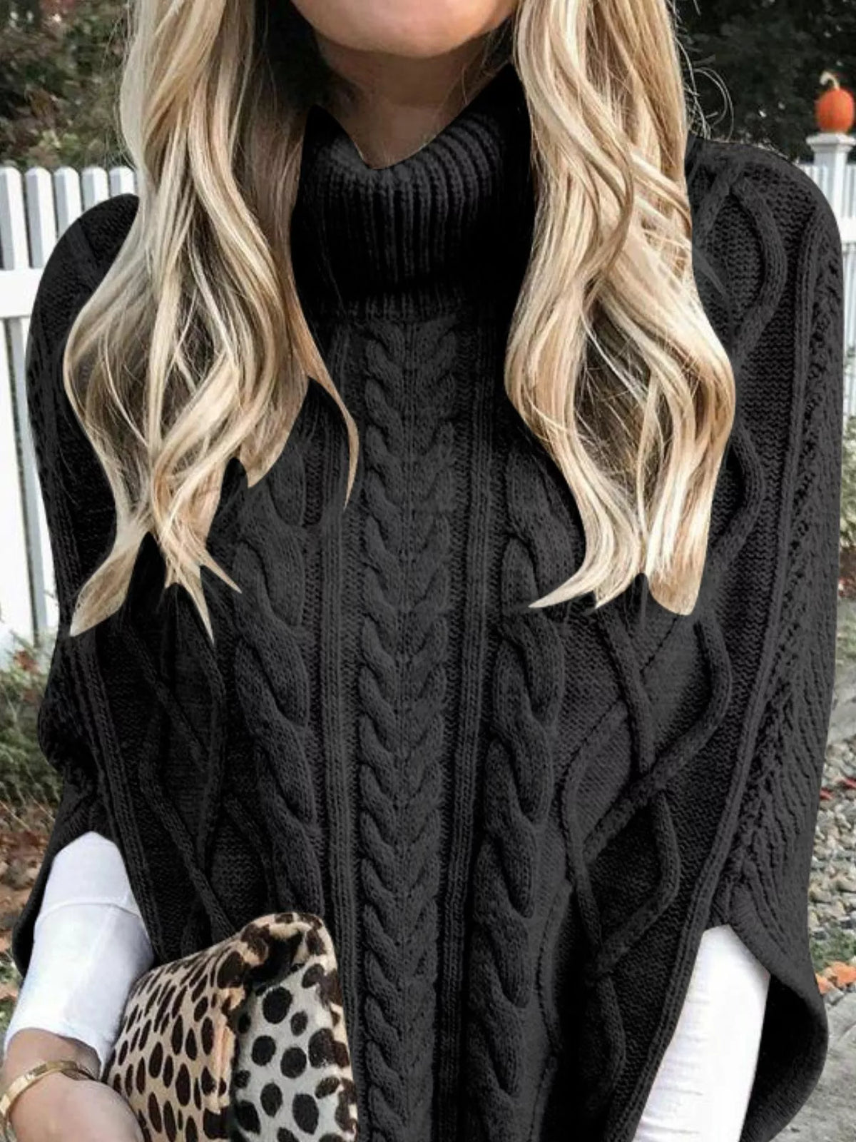 Black cable-knit turtleneck poncho cover-up close-up with raised cable stitches