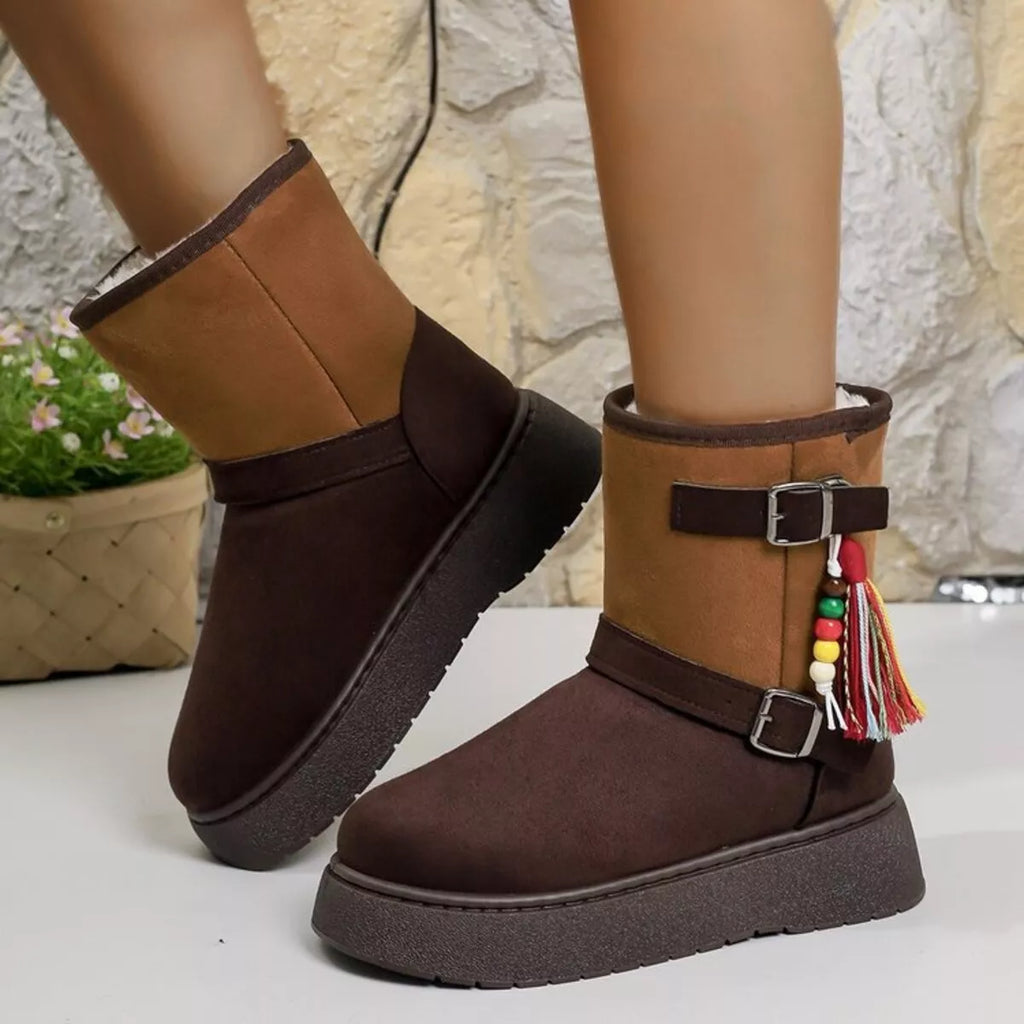 Two-tone ankle boots with buckled side straps, tassel detail, and chunky sole.