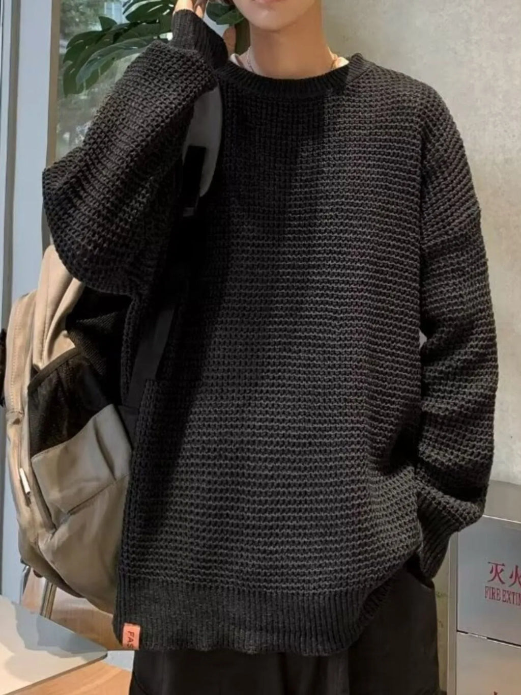 Black waffle-knit crewneck sweater, long sleeves, dropped shoulders