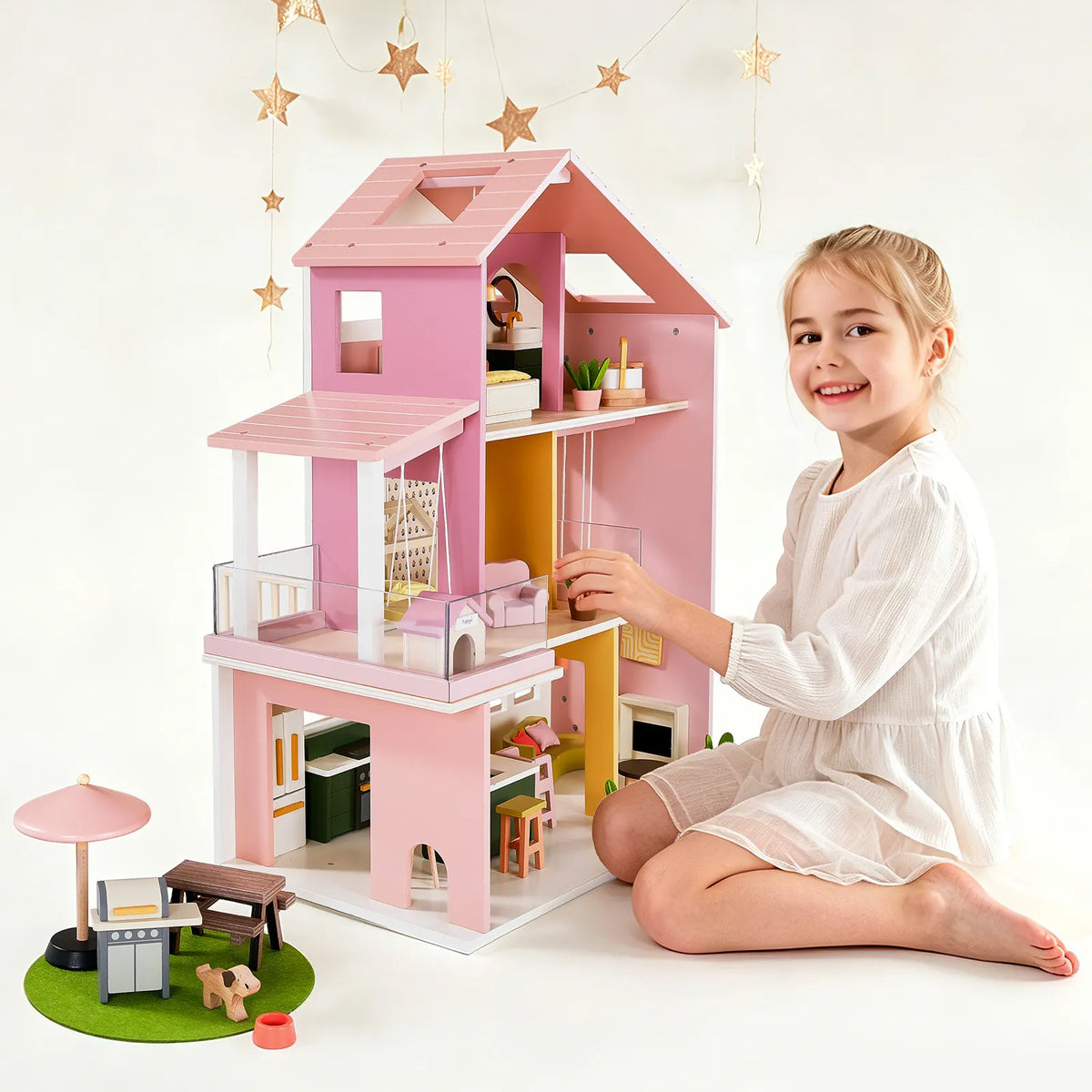 Pink dollhouse with stacked floors, staircase, and rooftop balcony detail