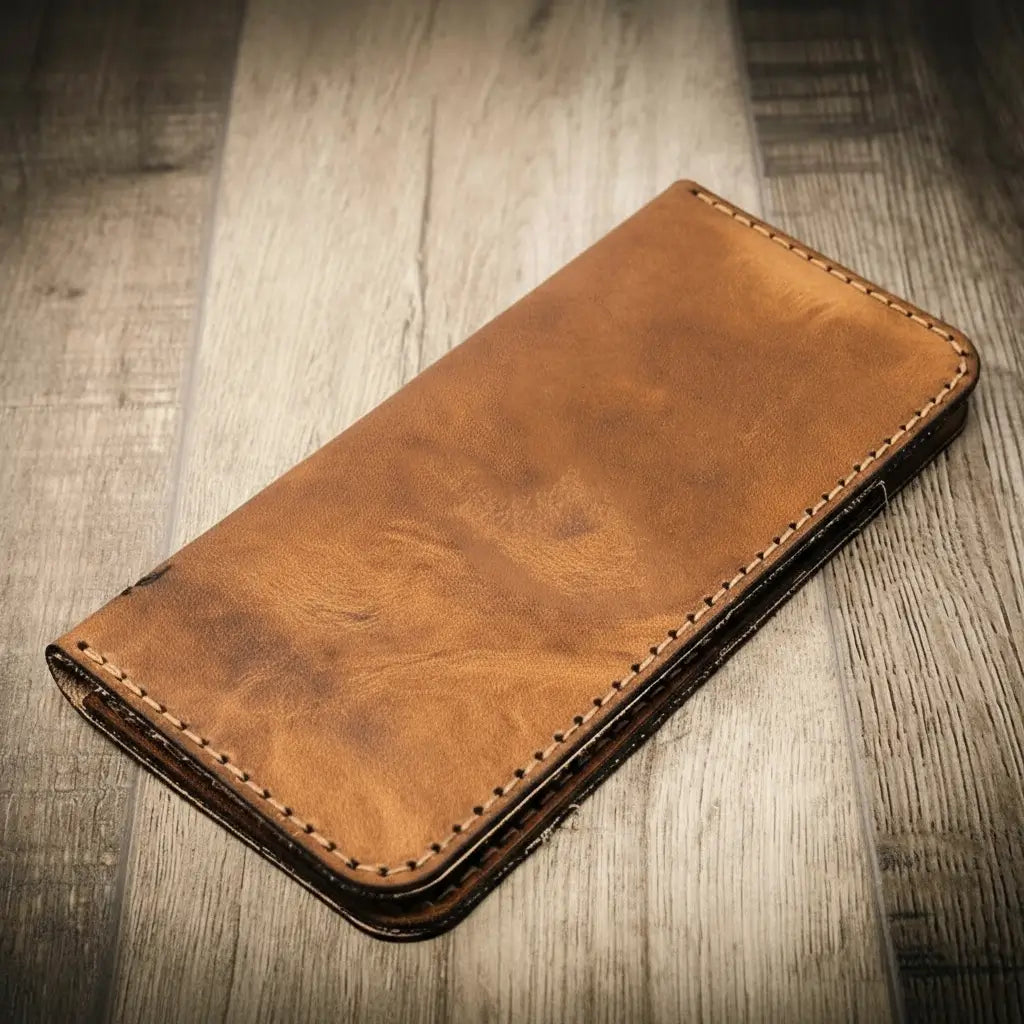 Tan long leather wallet, smooth front with stitched border and rounded corners.