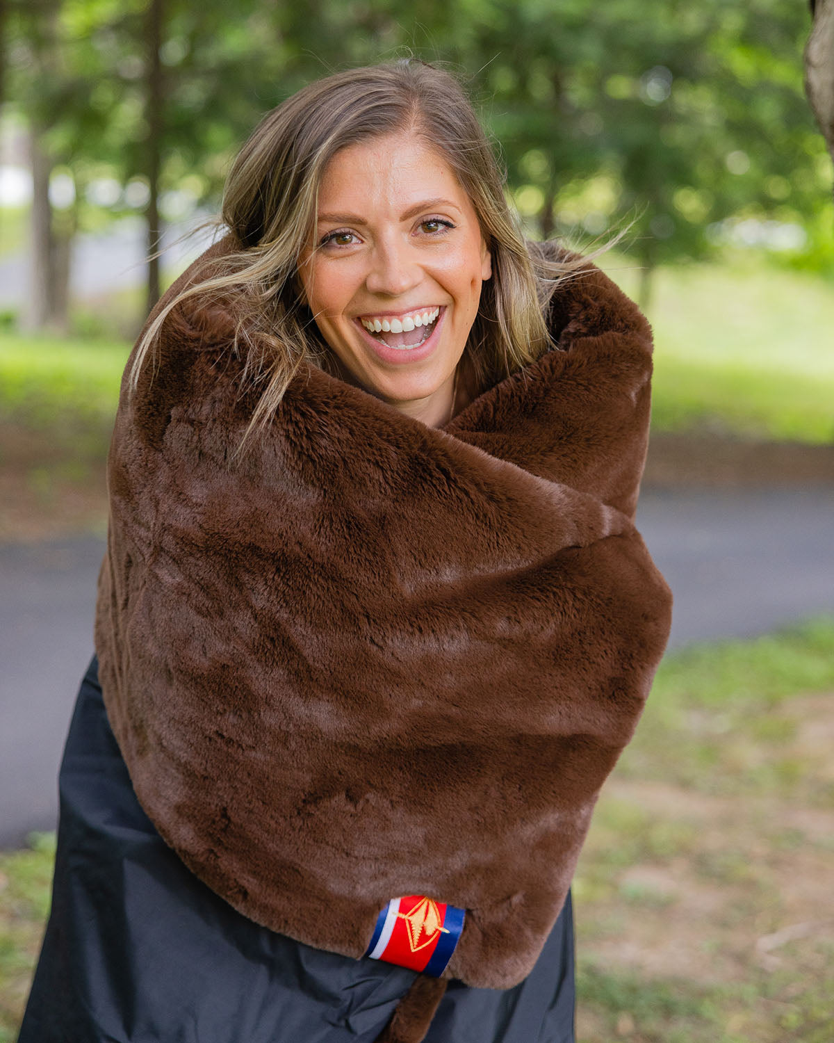 Outdoor blanket scarf-style wrap in dark brown plush fabric.