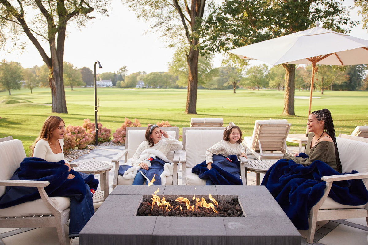 Navy outdoor blankets on patio chairs around a fire pit