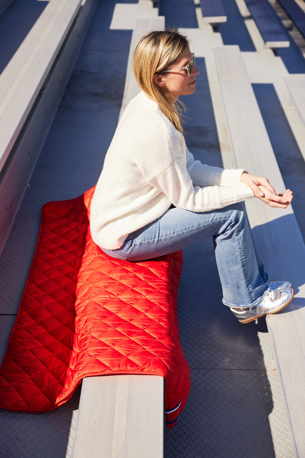 Red quilted puffer blanket with stitched diamond pattern, folded over