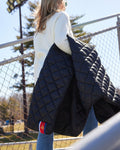 Navy quilted puffer blanket with stitched logo and pocket
