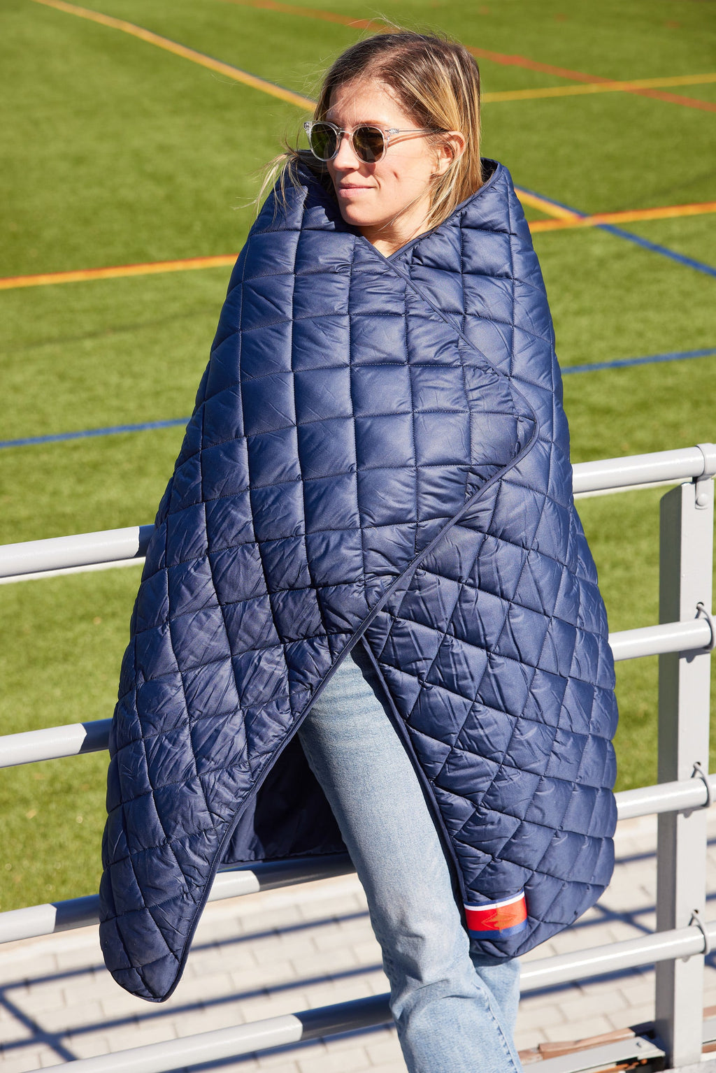 Waterproof puffer blanket with pockets, navy quilted cape-style wrap with cutout