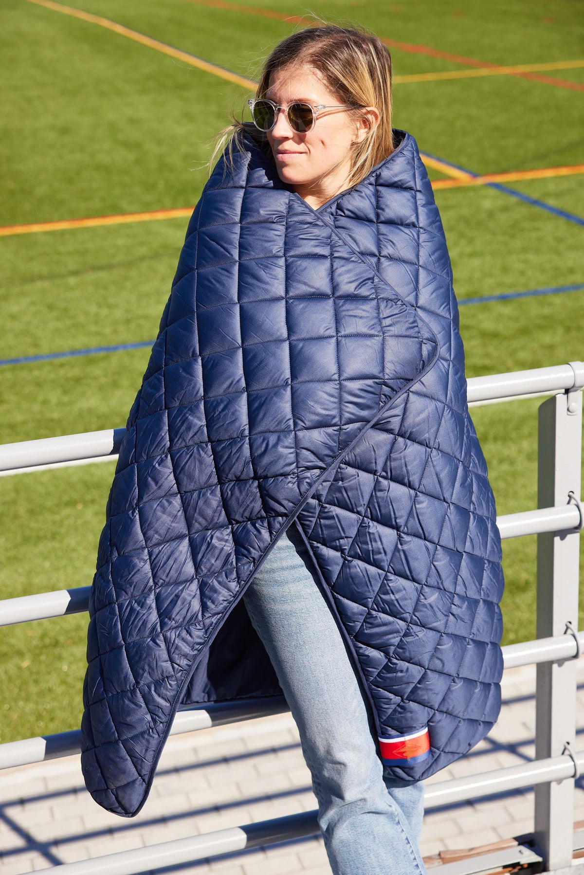 Waterproof puffer blanket with pockets, navy quilted cape-style wrap with cutout