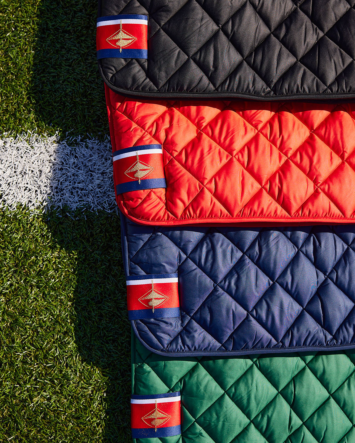 Waterproof puffer blanket with pockets, quilted panels with pocket flaps in black, red, navy, green