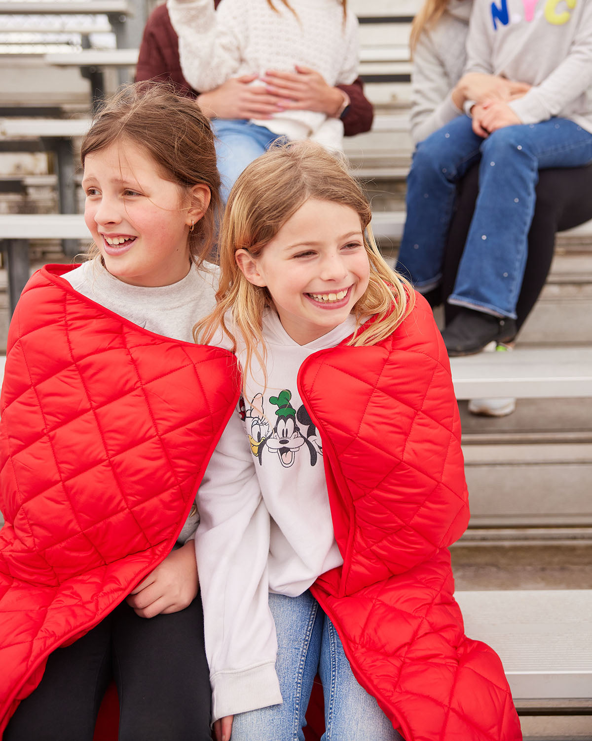 Red quilted puffer blanket with pocket, folded and held