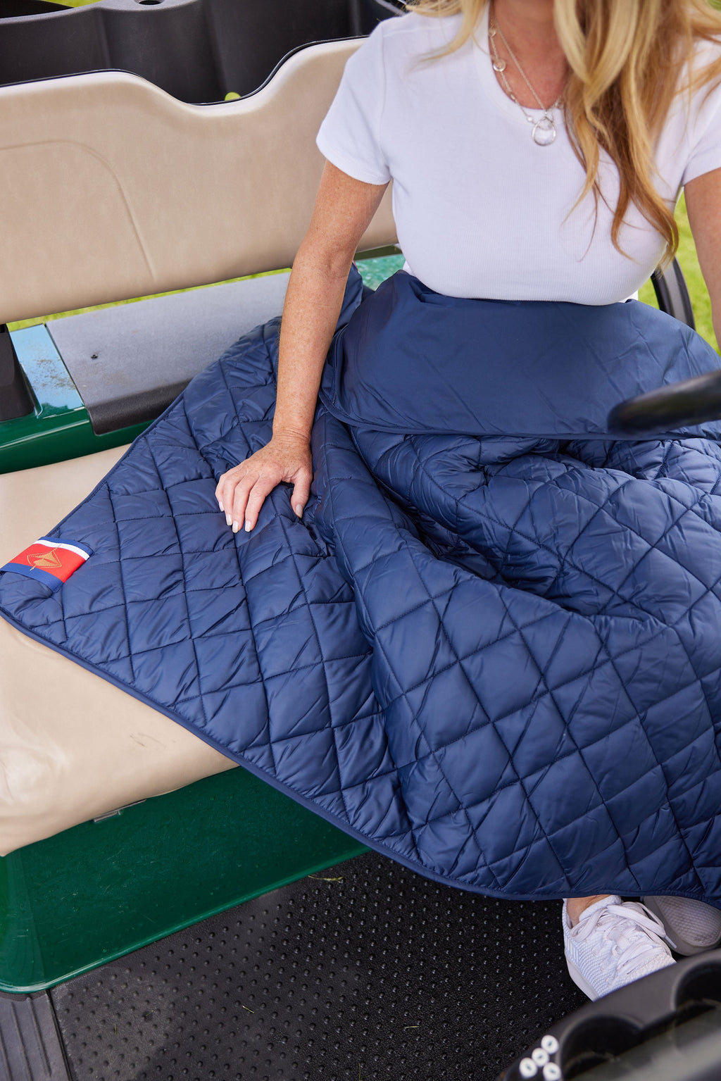 Navy quilted puffer blanket with stitched diamond pattern and folded edge