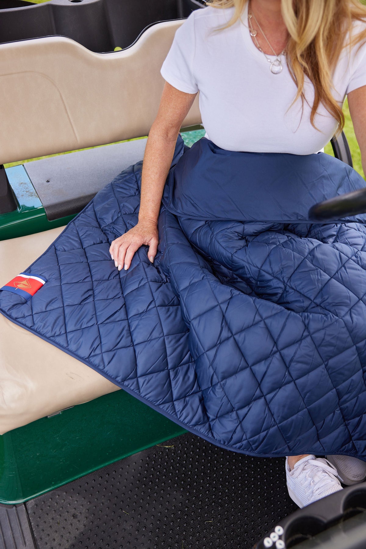 Navy quilted puffer blanket with stitched diamond pattern and folded edge