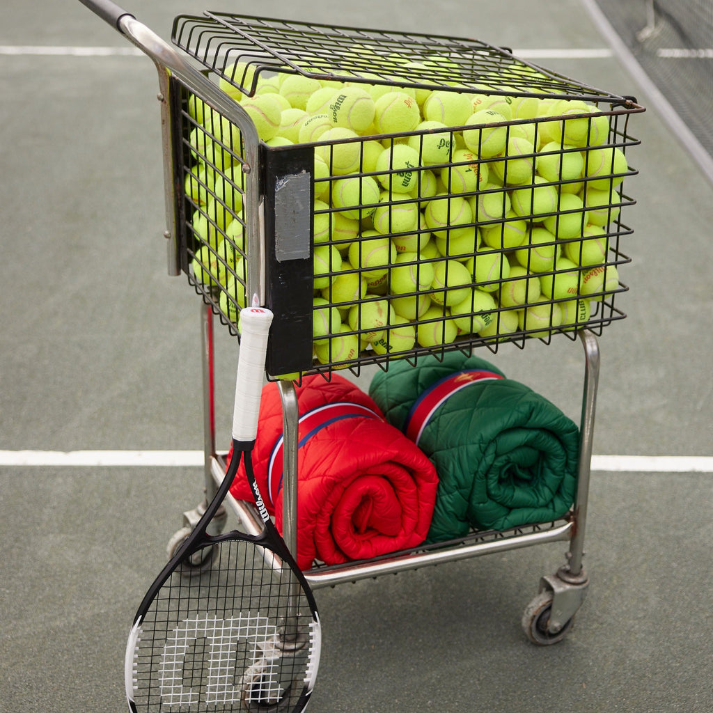 Waterproof puffer blanket with pockets, green folded quilted blanket on a cart