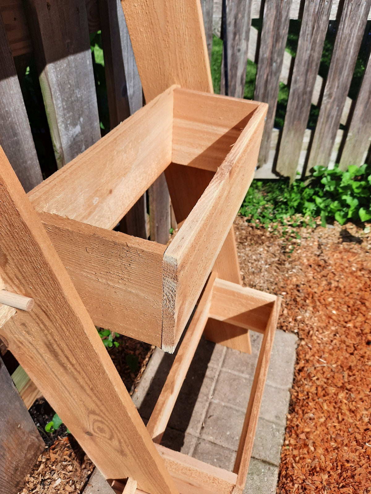Close-up of cedar ladder planter box frame with open two-tier planting trays