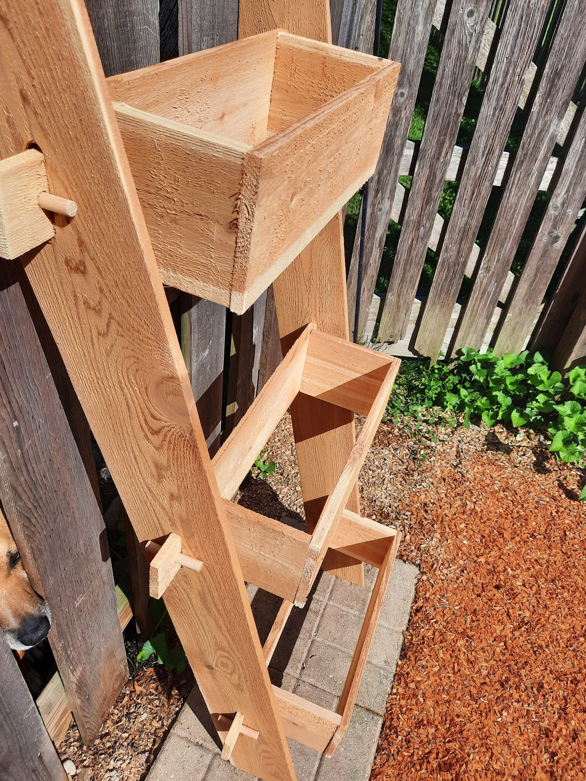Close-up of 3-tier vertical cedar standing planter box with three open wooden troughs