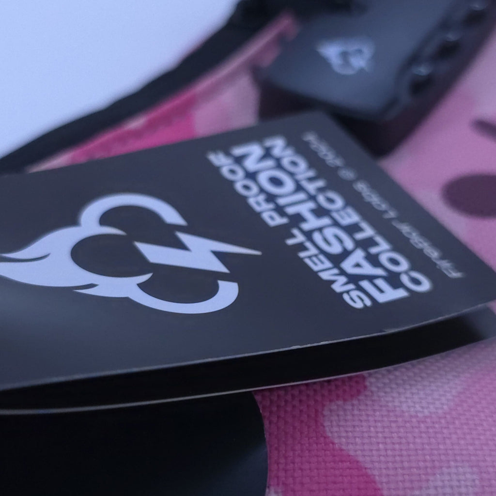 Pink camo crossbody bag close-up of black tag with icon and text