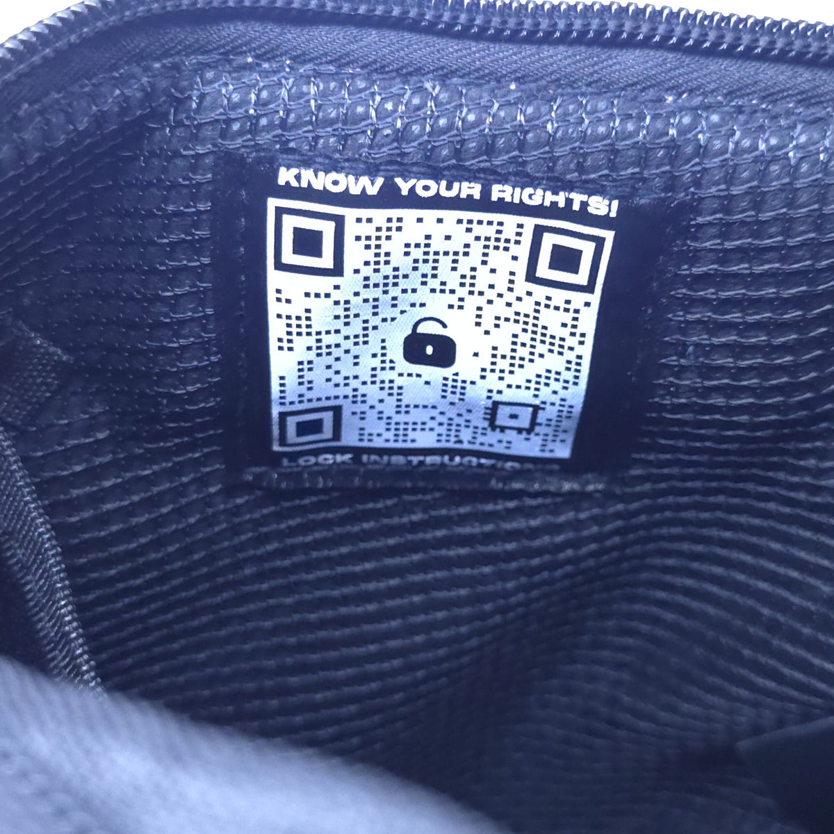 Smell proof crossbody bag interior with QR compliance label and stitched fabric lining