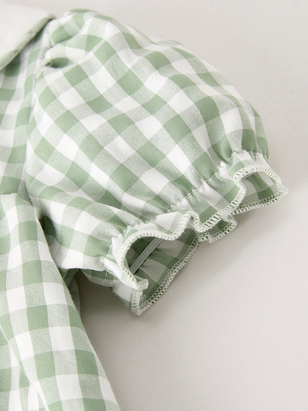 Green gingham puff sleeve with white ruffle cuff and gathered detailing