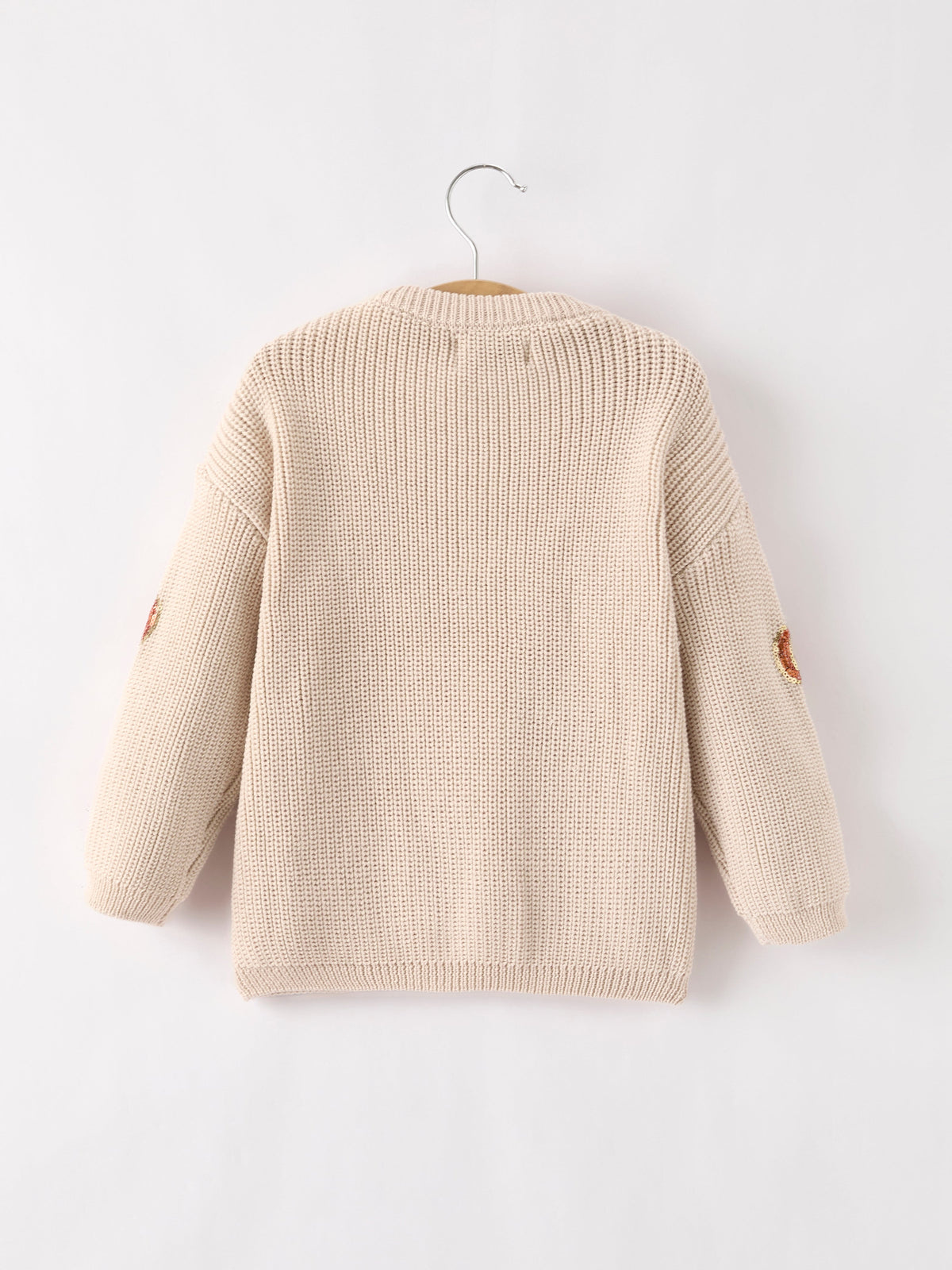 Back view: beige knit pullover sweater with knit texture and pumpkin detail