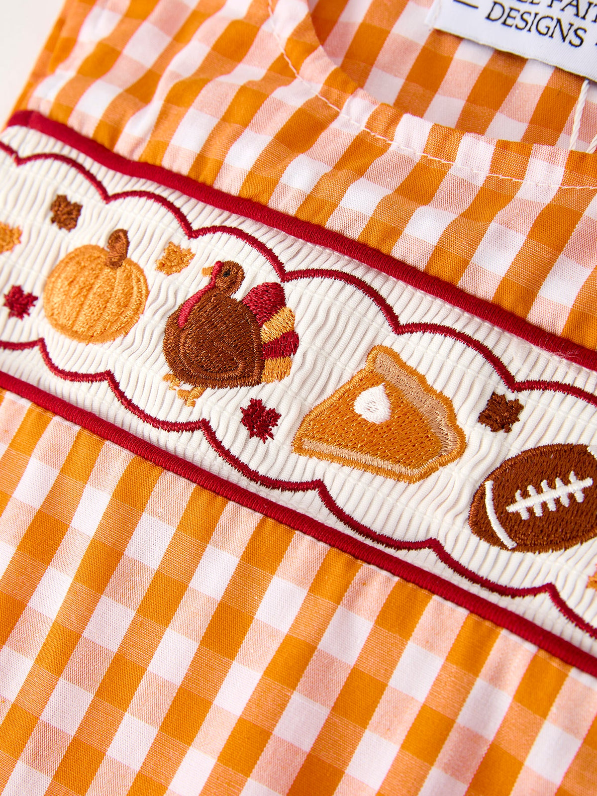 Embroidered fall icons on orange gingham romper trim: turkey, pumpkin, football