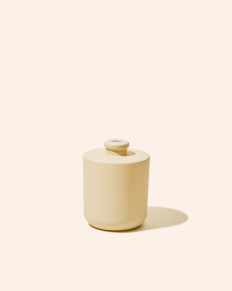 Aura® diffuser bottle in matte cream with circular top vent