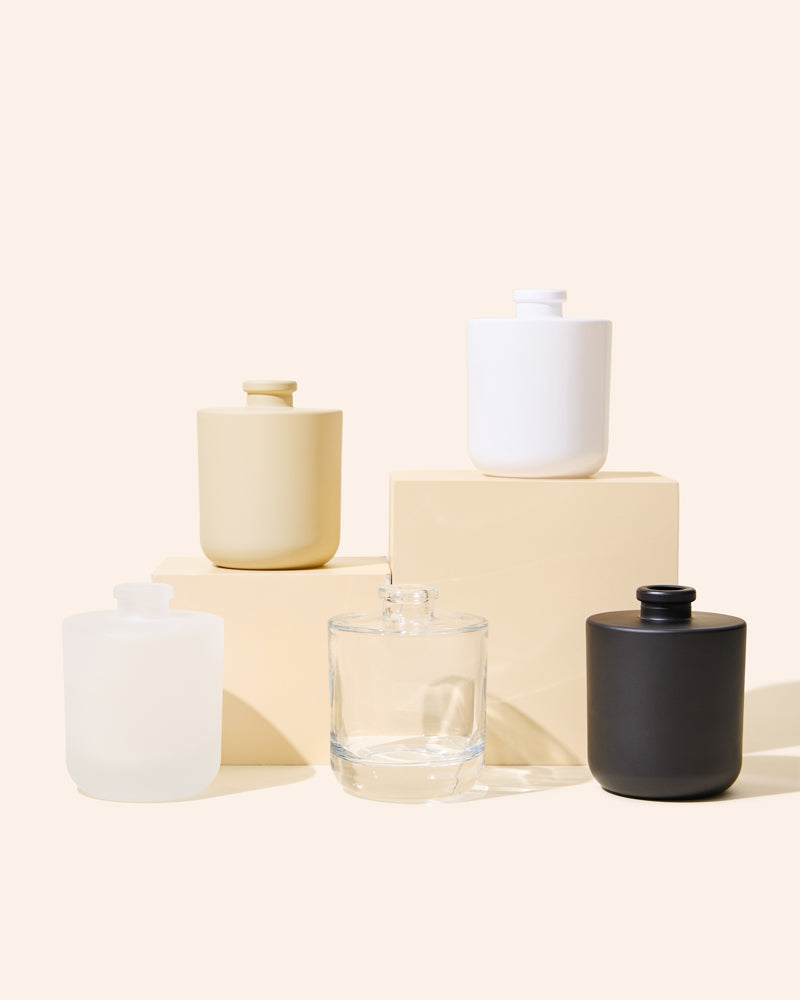Aura® diffuser bottle set in matte cream, translucent amber, matte black, and clear