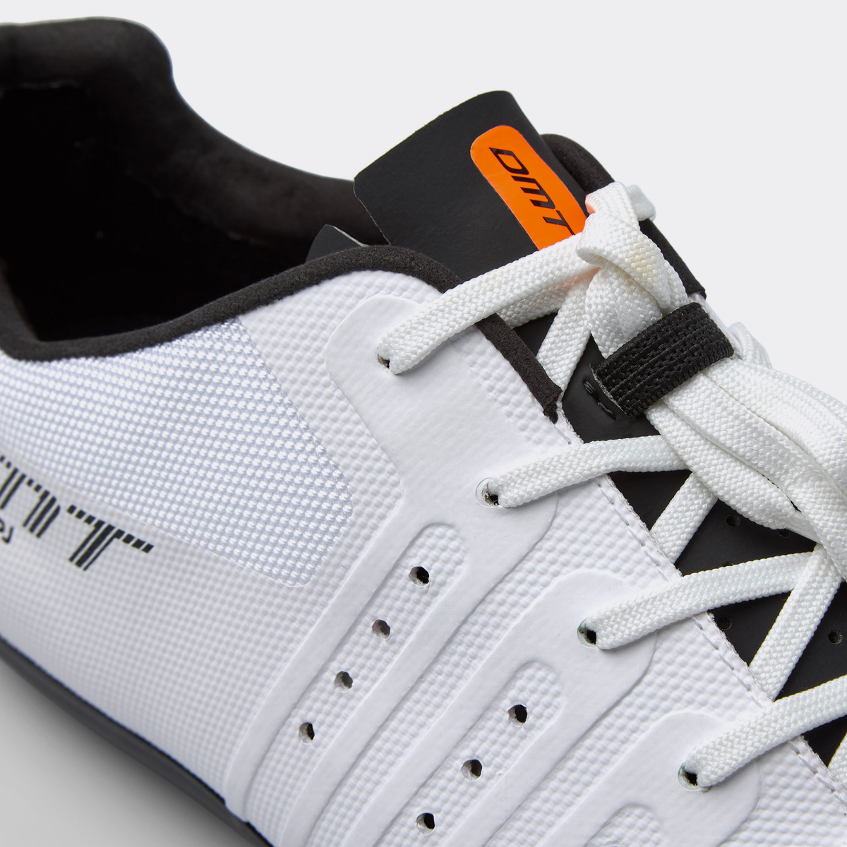 Close-up of white road cycling shoe tongue, laces, and orange brand tab