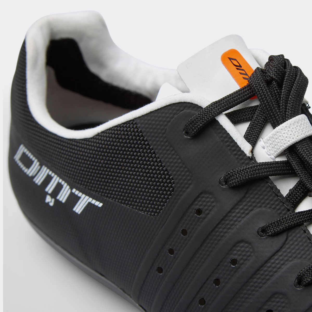 DMT KR4 PJ road shoe close-up, black mesh with orange tongue tag and laces