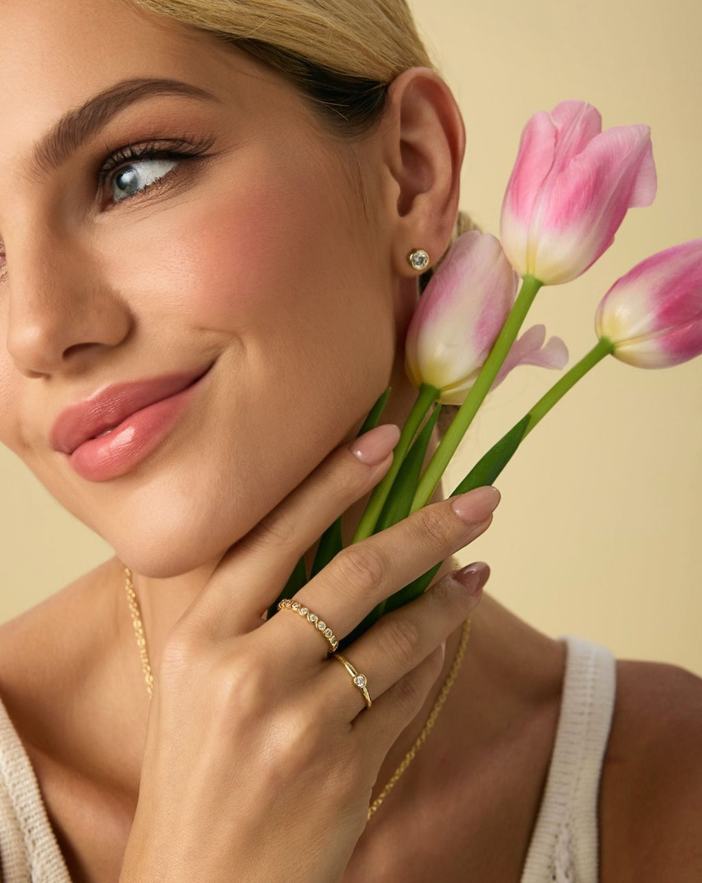 Gold round diamond stud earrings with bezel setting on visible ear