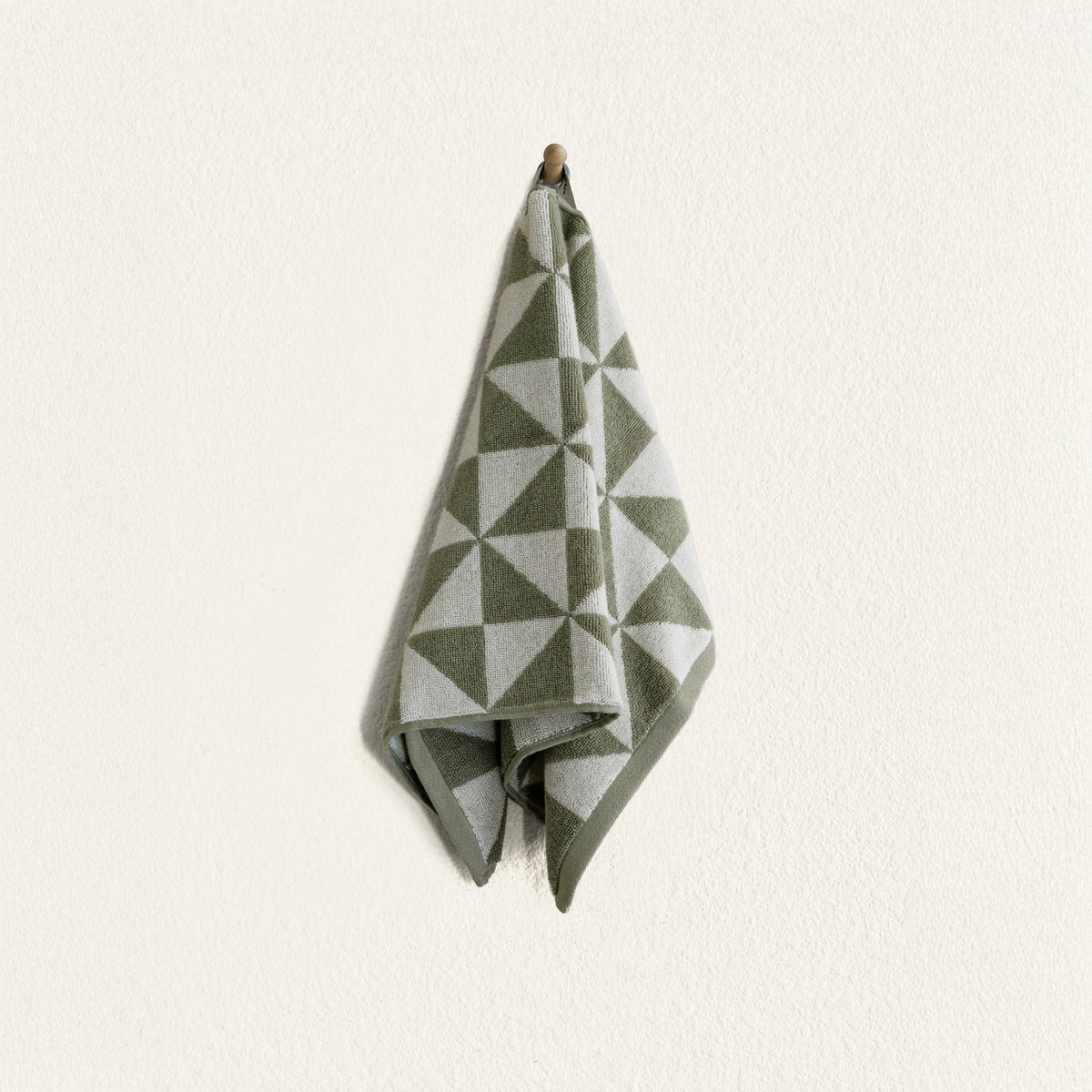 Sage and ecru geometric cotton hand towel folded, hanging loop at top