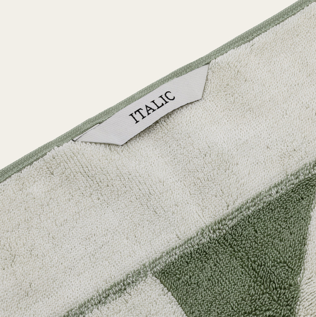 Sage and ecru geometric cotton towel edge with ITALIC label close-up