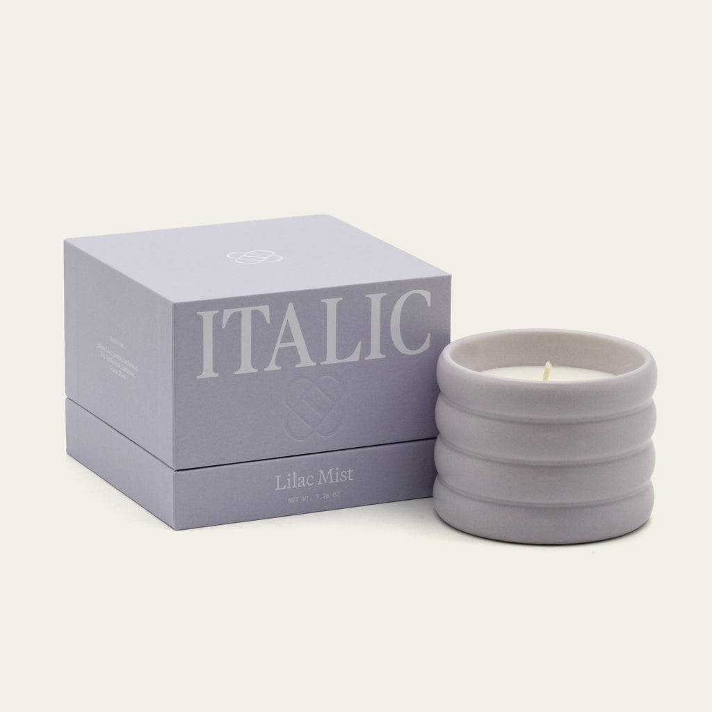Lilac ceramic soy candle with lit wick in ribbed stoneware vessel, Lilac Mist scent.