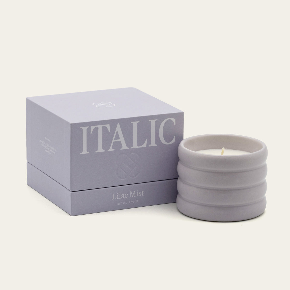 Lilac ceramic soy candle with lit wick in ribbed stoneware vessel, Lilac Mist scent.