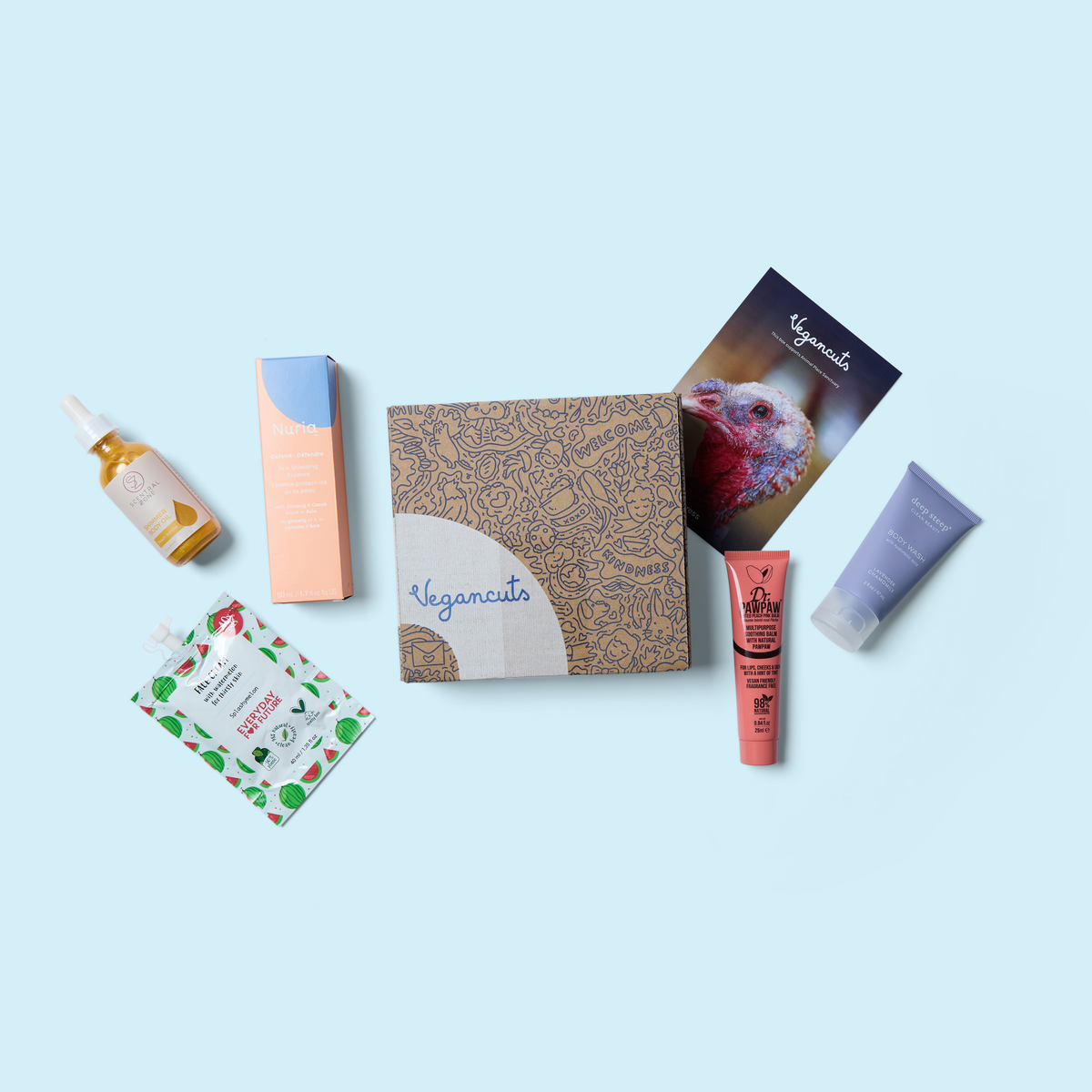 Beauty box with assorted skincare bottles, tubes, and leaf-patterned sachet