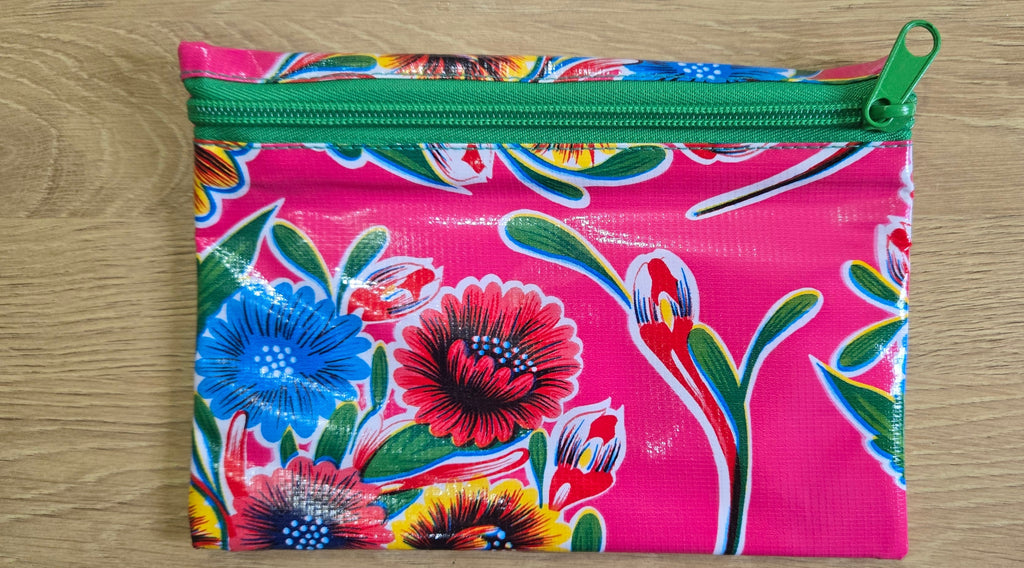 Pink floral zippered pouch with green zipper and colorful blossoms