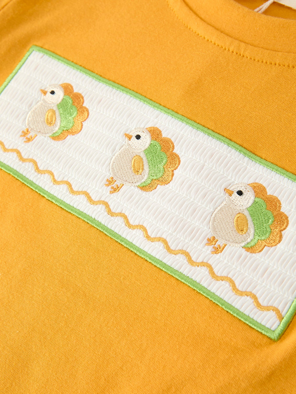 Yellow long-sleeve shirt front panel with three embroidered turkey faces and green trim