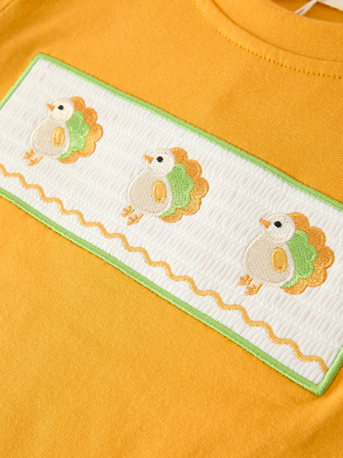 Yellow long-sleeve shirt front panel with three embroidered turkey faces and green trim