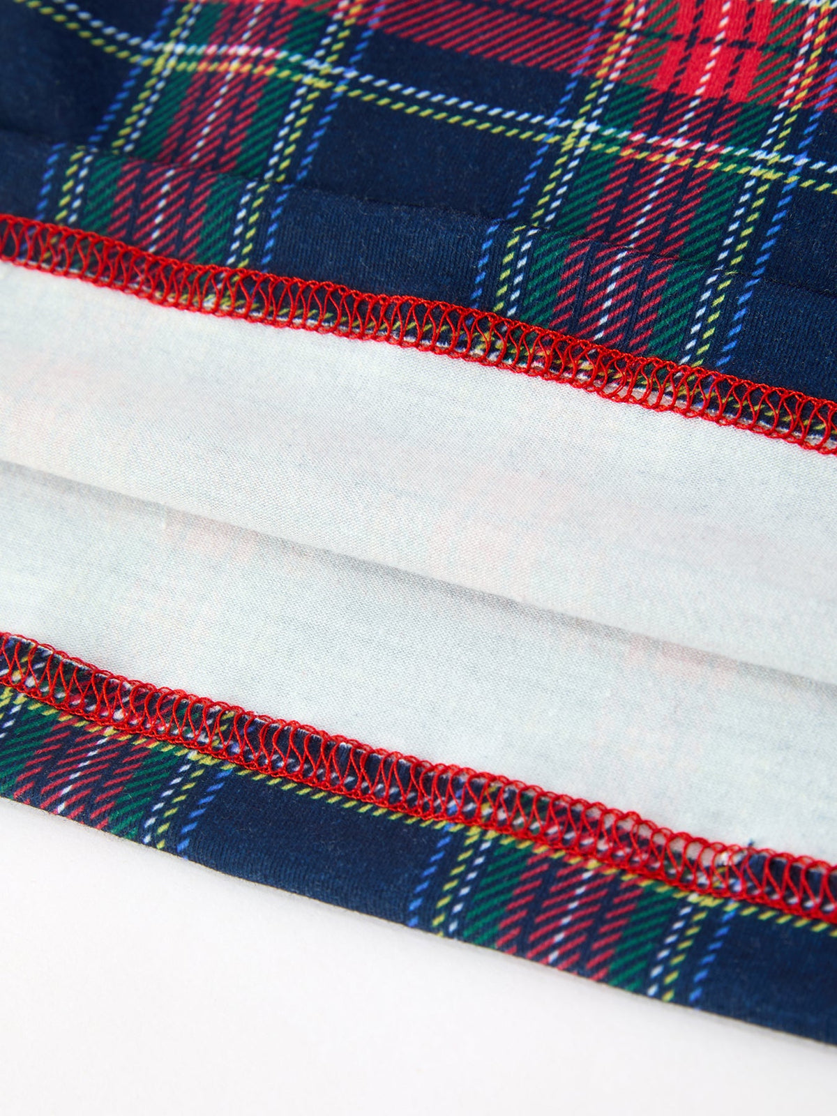 Plaid dress hem with red stitched trim, blue green red tartan