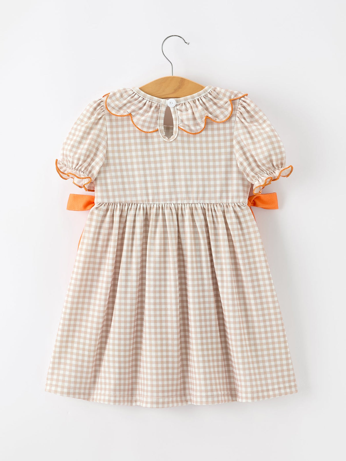 Back of girls' gingham Thanksgiving dress with short sleeves and orange side bows
