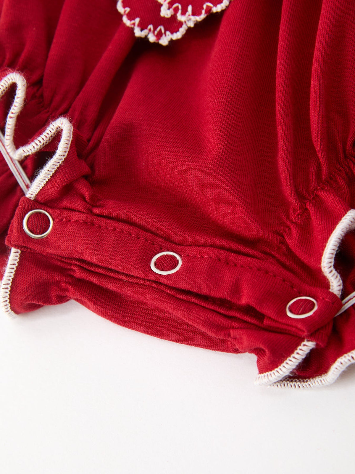 Red bubble romper with snap-button leg openings and white scalloped rickrack trim